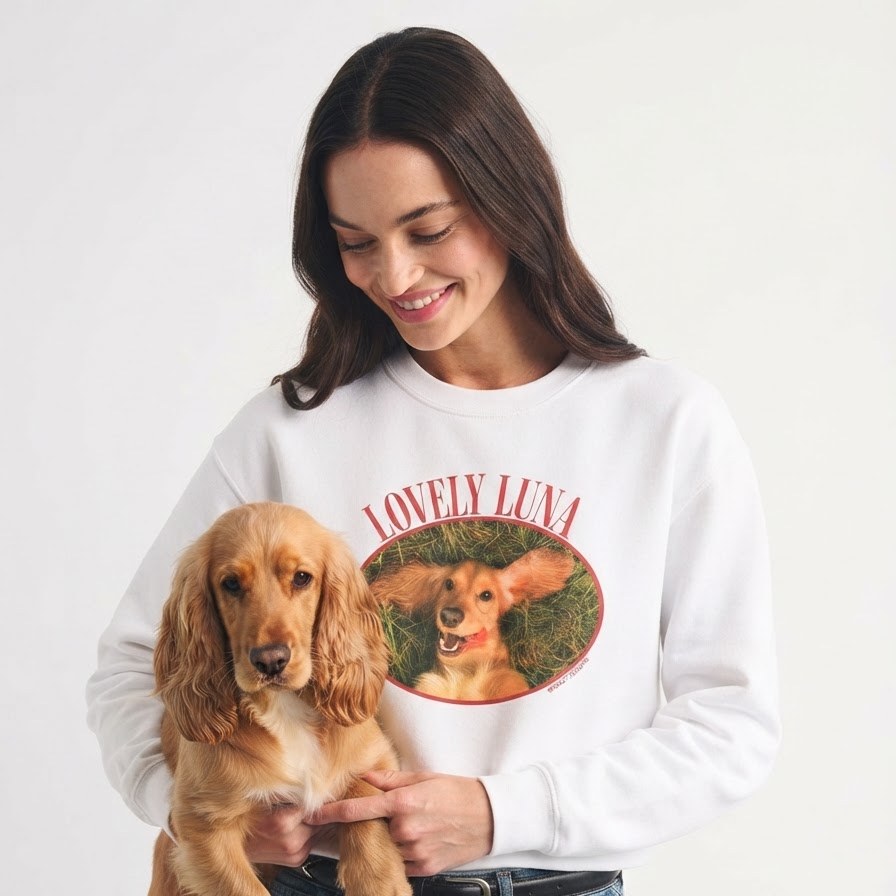 Someone holding their cocker spaniel, wearing a white sweatshirt printed with the same dog's photo and name